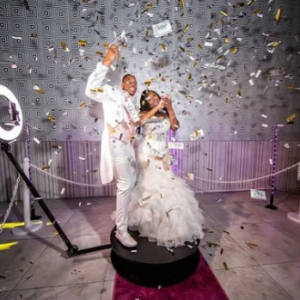 a couple using a 360 selfie booth for their wedding